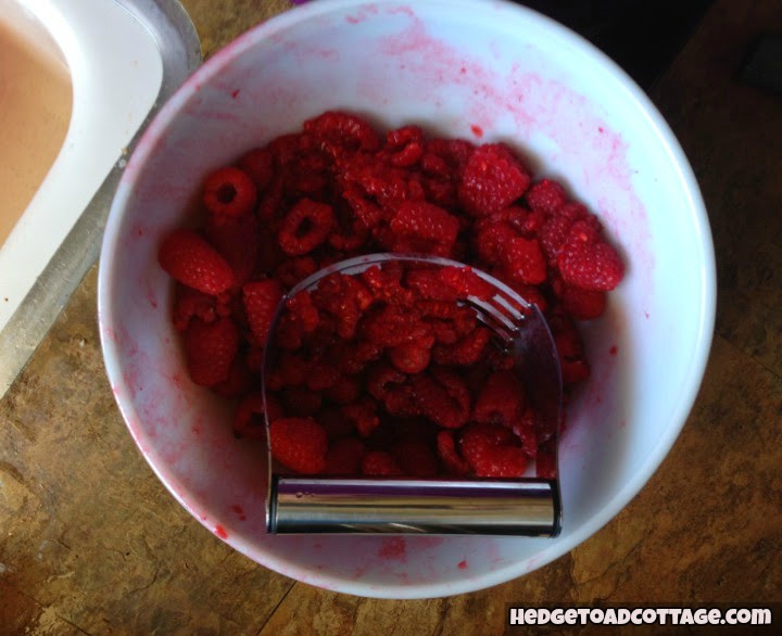mashing berries to make jam